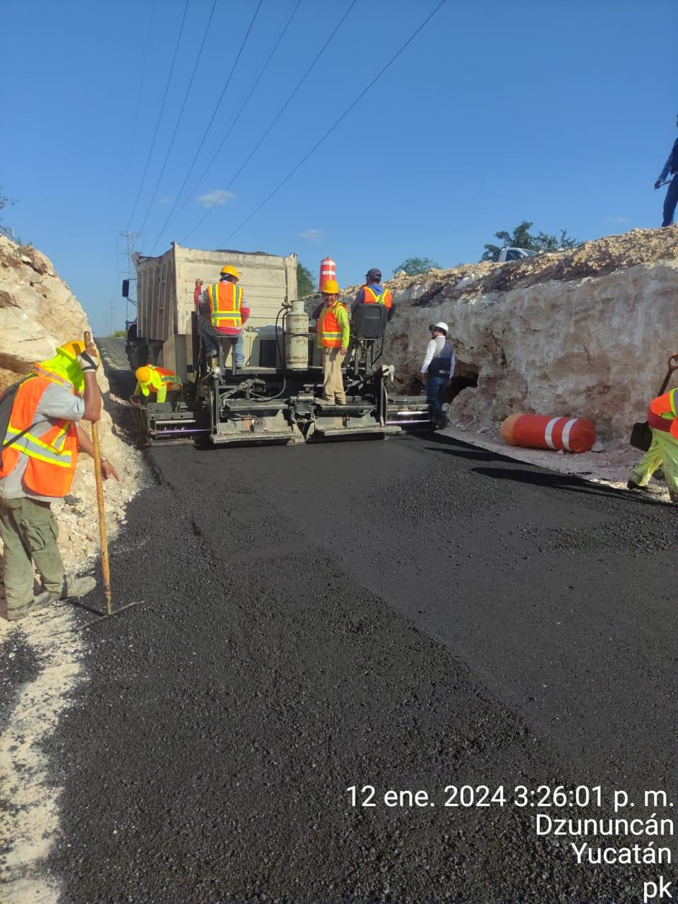 Pavimentadora tendiendo carpeta asfáltica con la cuadrilla de Steelbeird en obra